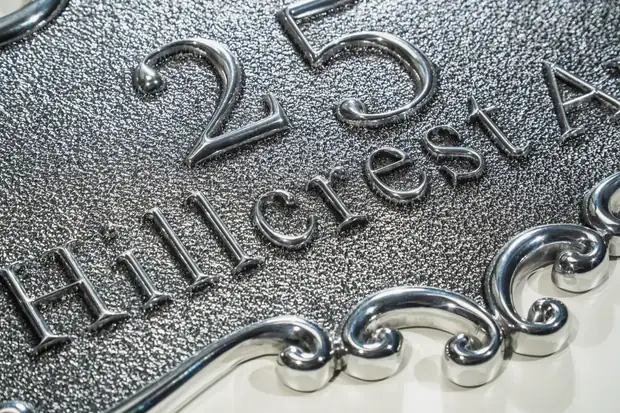 Textured custom address plaque close-up with raised number and street name