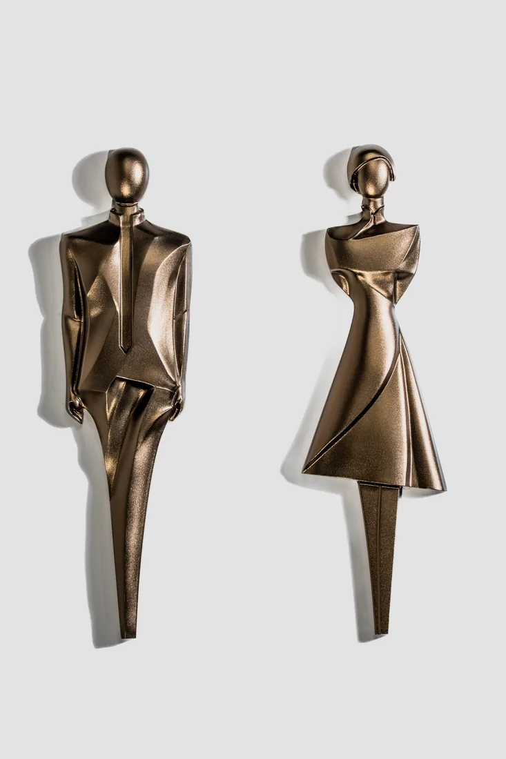 Cast bronze-finish sculptural man and woman restroom figures