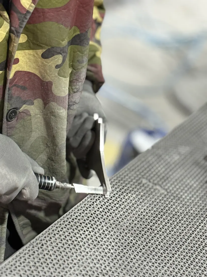 Worker polishing custom sign material before finishing