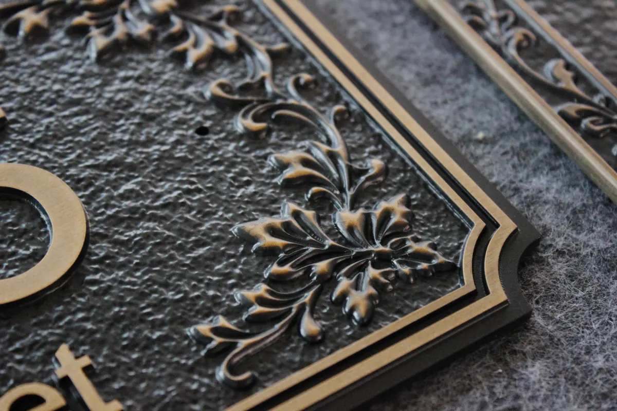 Close-up of ornate raised border on carved plaque