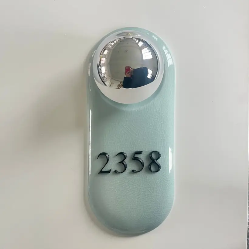 Pale ceramic hotel room number sign with raised detail