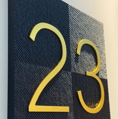 Black and gold raised number plaque close-up for apartment or hotel door